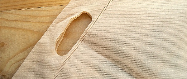 千庫網_放棄塑料袋的概念，無紡布生態袋，平鋪在淺色木質背景上，頂視圖，復制空間_攝影圖編號14950906